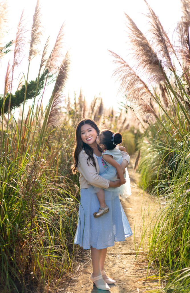 Mother holding daughter during a sunset family session