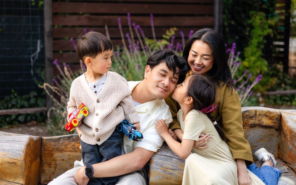 Family with two young children sharing a playful moment during an outdoor family photography session