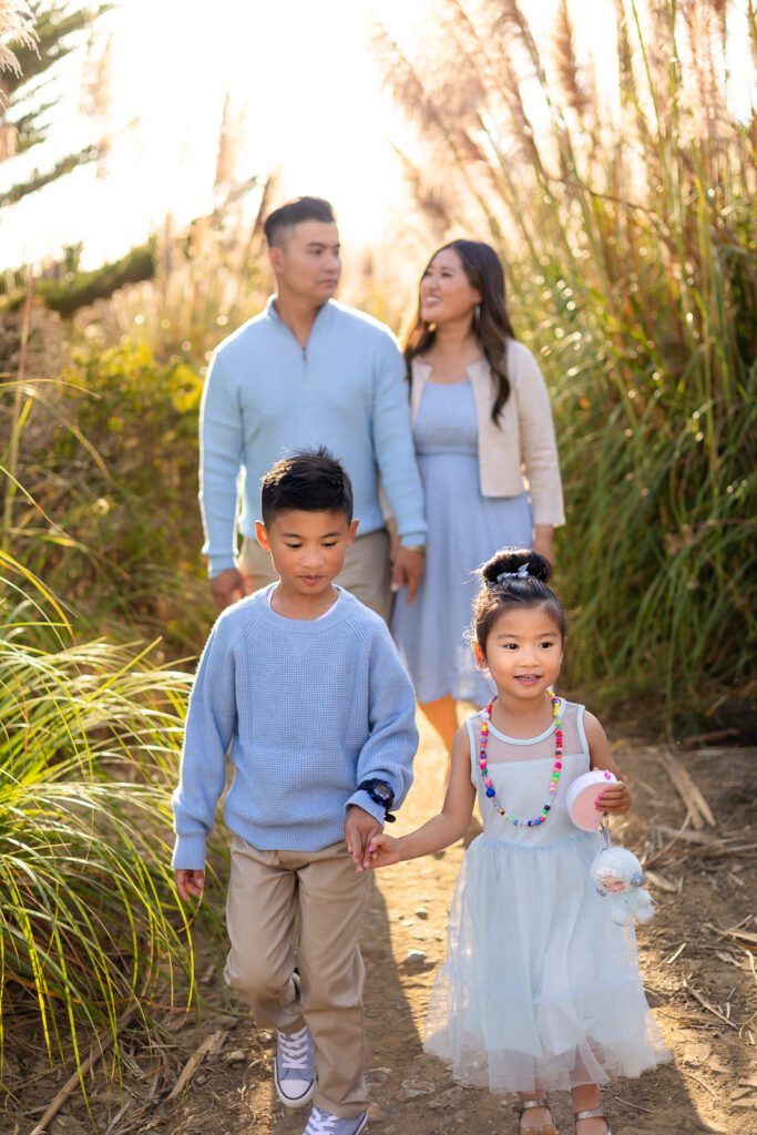 Family walking together through a coastal grass field in Pacifica San Francisco Peninsula