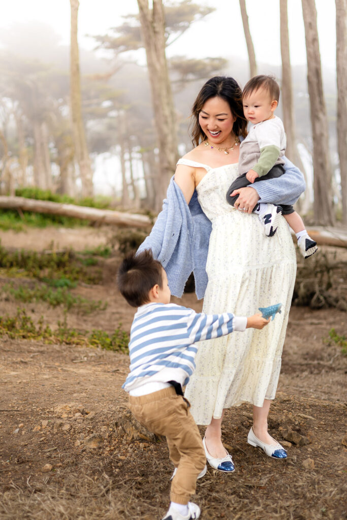 Mom and two young children wearing coordinated blue and cream family photo outfits