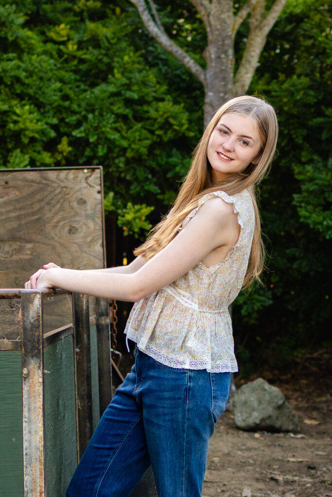 Senior wearing jeans and a simple white top, a classic example of what to wear for senior portraits