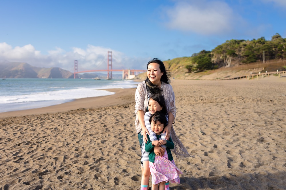 Family enjoying Baker Beach with the Golden Gate Bridge in the distance.