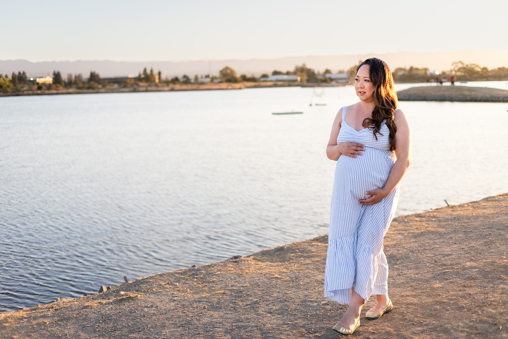 Expecting mother walking beside the bay at Coyote Point Recreation Area.