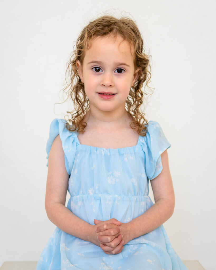 Girl wearing a light blue dress that photographs beautifully for picture day.