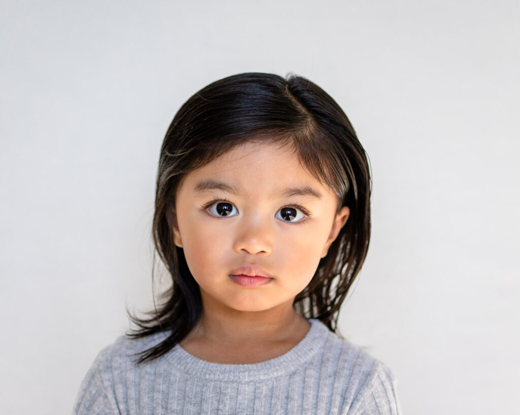 Young girl wearing a soft gray sweater for a timeless school picture day portrait.