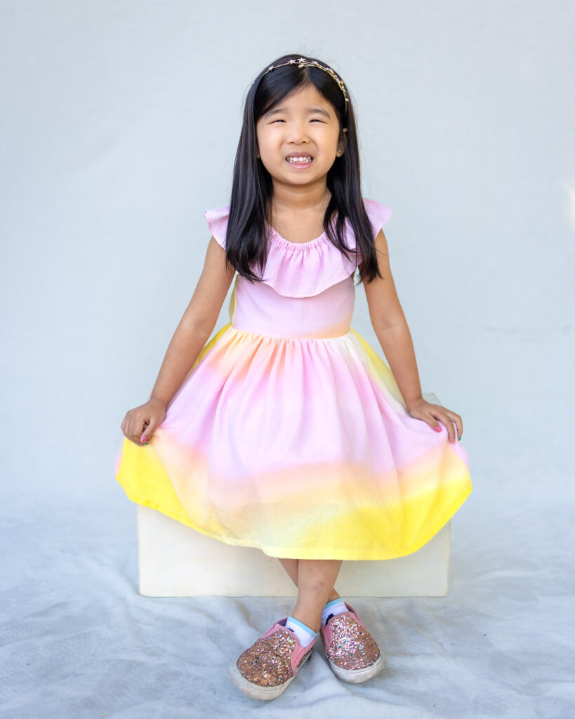 Girl wearing a colorful pastel dress that stands out beautifully in school portraits.